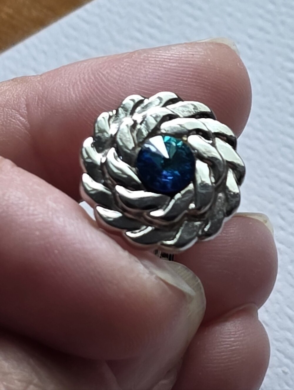 silver-tone braided rope design cufflinks featuring central blue glass crystal